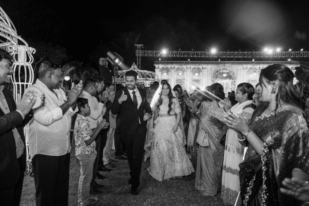 Bride and groom walking together through the crowd towards the wedding stage