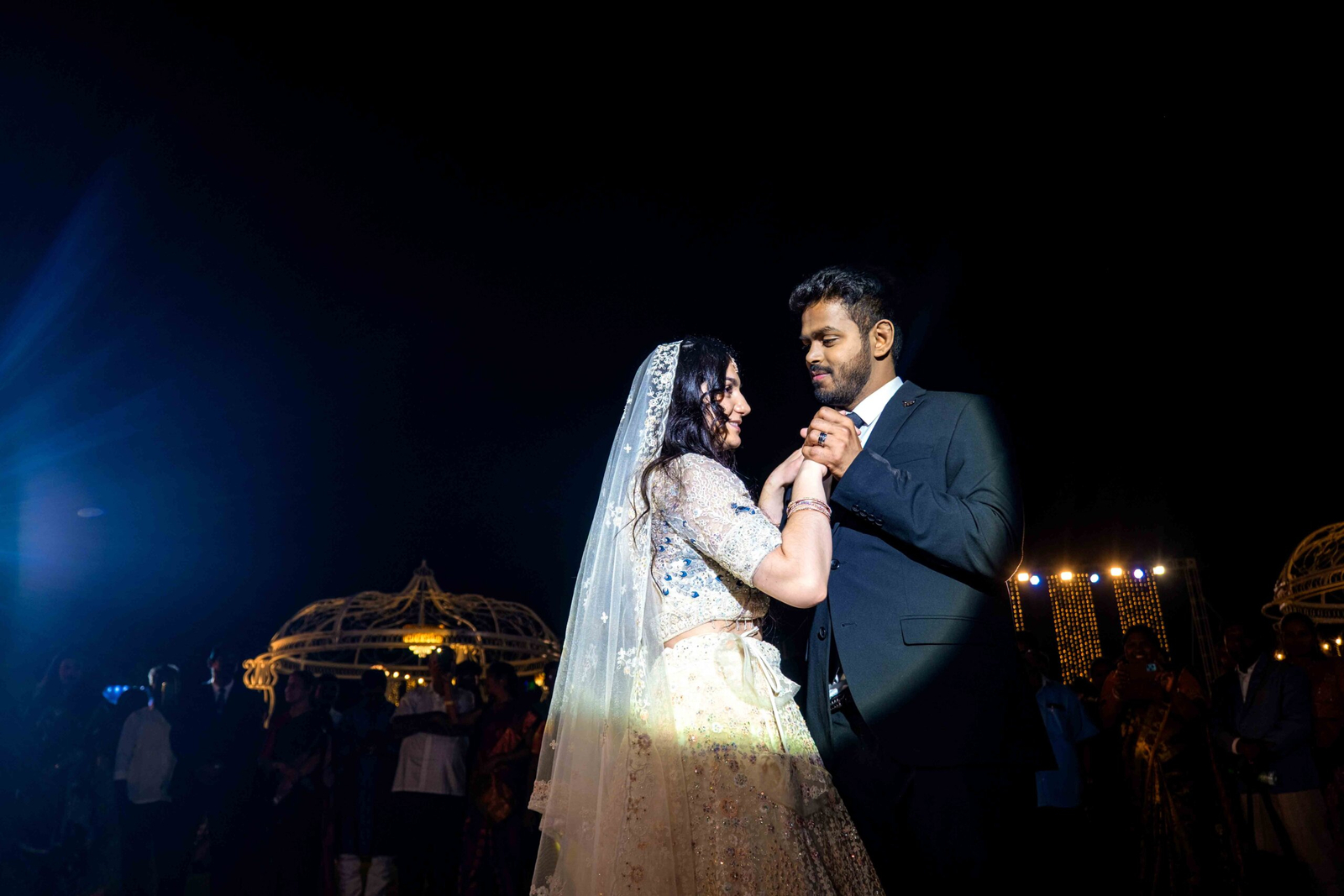 Bride and groom dancing together, holding hands, during their wedding celebration