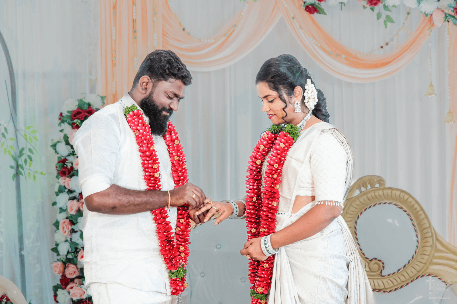 The groom gently places a sparkling engagement ring on the bride’s finger during their ceremony, their smiles capturing the magic of the moment.