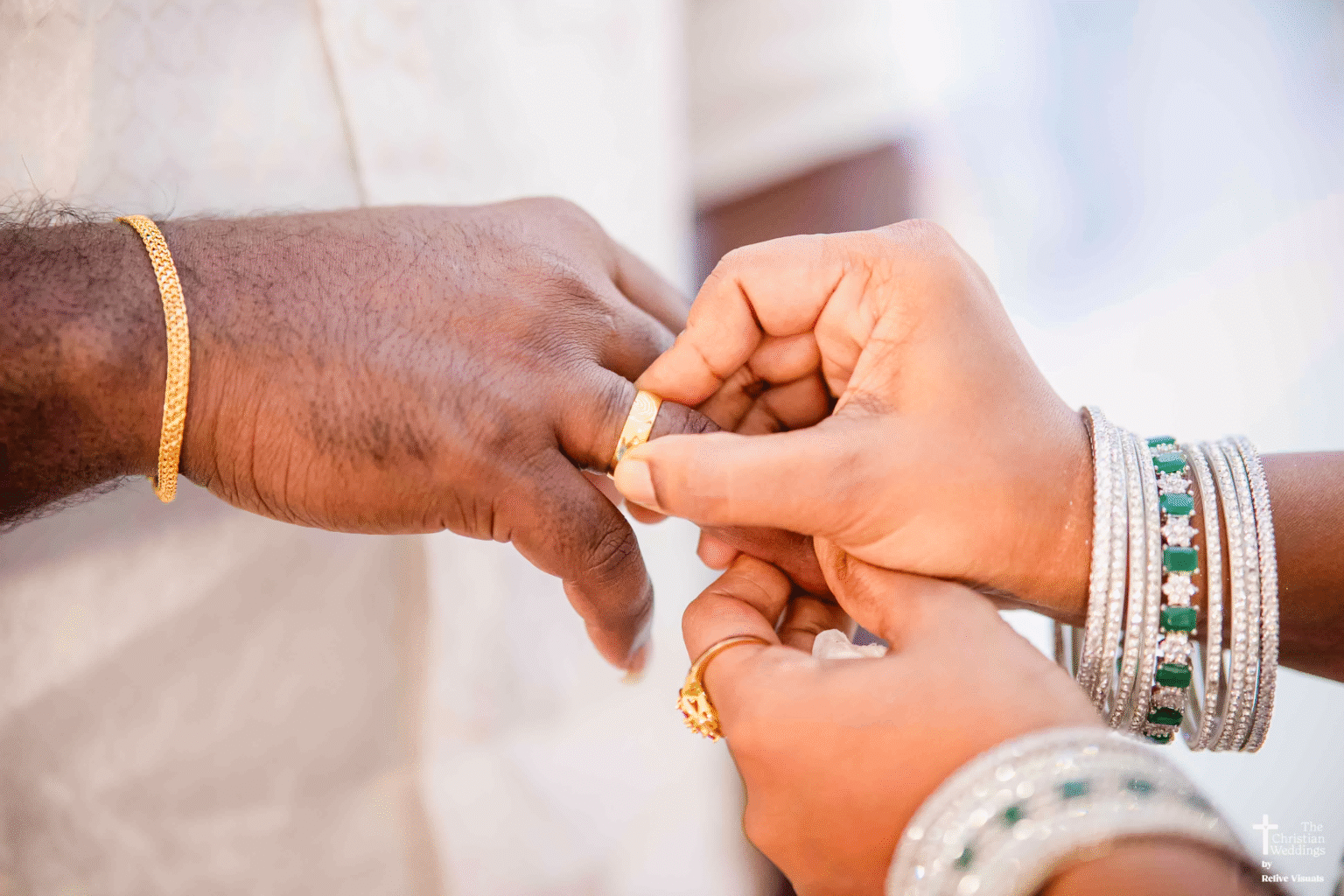 A close-up of the bride gently placing a ring on the groom’s finger during their engagement ceremony, her eyes filled with joy and love.